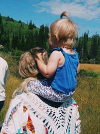 Rear view of people against plants