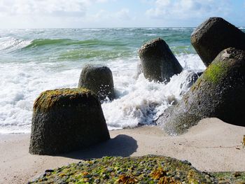 Scenic view of rocks on beach against sky