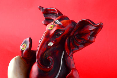 Close-up of statue against red background