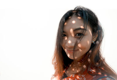 Close-up portrait of a young woman over white background