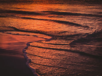 Shadow of man walking on beach during sunset