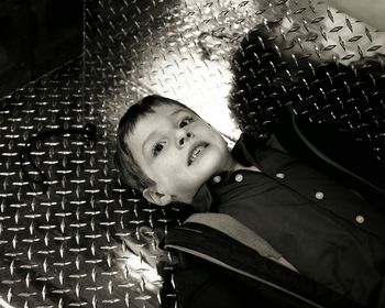 High angle view of boy lying on diamond plate