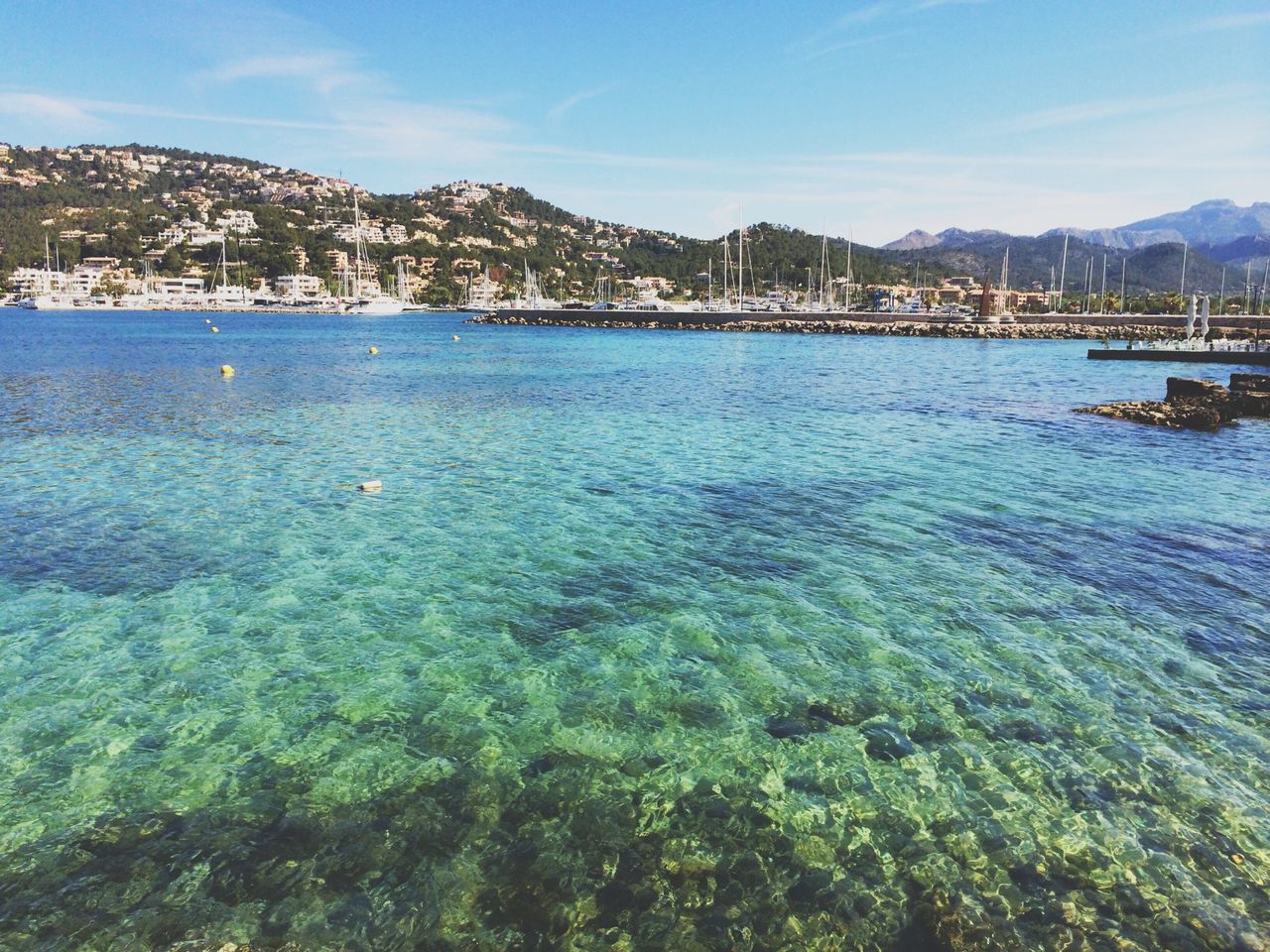 mountain, water, blue, sky, mountain range, tranquil scene, tranquility, scenics, sea, beauty in nature, nature, lake, built structure, nautical vessel, day, building exterior, idyllic, architecture, outdoors, incidental people