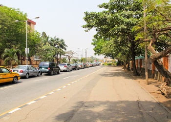 Cars in traffic on street against clear sky