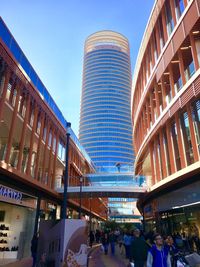 People in modern building against blue sky