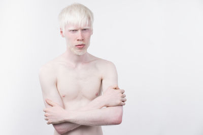 Portrait of shirtless man standing against white background