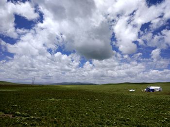 Scenic view of field against cloudy sky