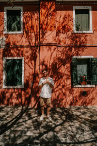 Full length of a boy standing against building