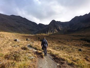 Rear view of man walking on footpath