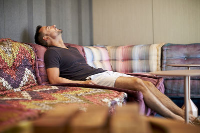 A man relaxes on a comfortable modern couch.