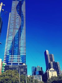 Low angle view of modern buildings against blue sky