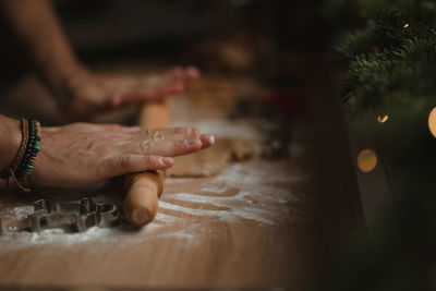 Closeup of man hands making gingerbread from dough at home