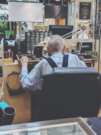 Rear view of man sitting on chair