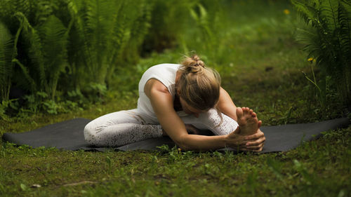 Woman practicing yoga in park 