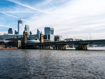 Bridge over river against sky in city