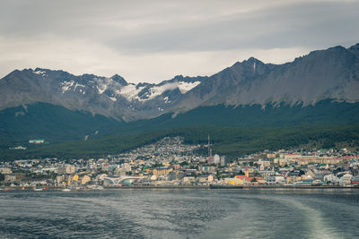 Scenic view of sea by townscape against sky