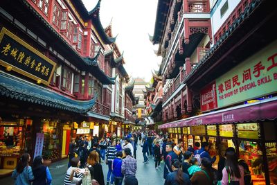 People on street amidst buildings in city