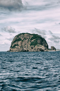 Scenic view of rock formation in sea against sky