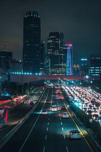 High angle view of traffic on city street and buildings at night