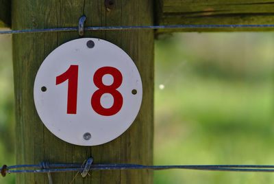 Close-up of number on wooden post