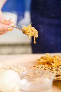 Close-up of person holding food in spoon