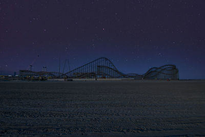 Bridge over land against sky at night