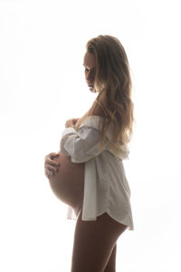 Side view of woman standing against white background