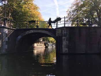 Arch bridge over river against sky