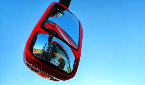 Low angle view of sunglasses against clear blue sky