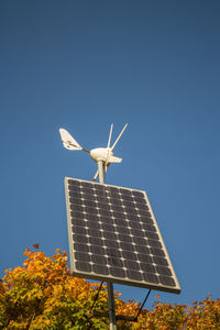 Low angle view of traditional windmill against clear blue sky