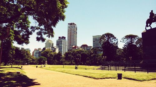 Low angle view of trees in city against sky