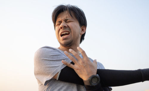 Low angle view of man standing against clear sky