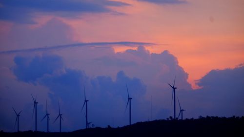 Silhouette of wind turbine against sky during sunset