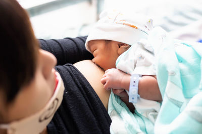 Midsection of mother feeding breast milk to baby