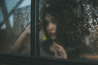Young woman sitting in car during rainy season