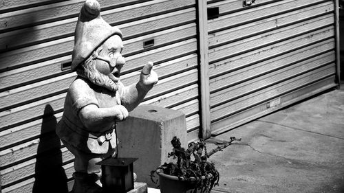 High angle view of garden gnome against shutter