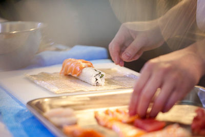 Midsection of woman preparing food on cutting board