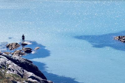 Man surfing on rock in sea