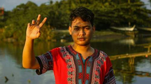 Portrait of young man standing in lake