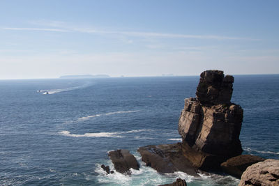 Scenic view of rocks in sea against sky