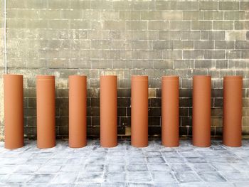 Row of brown bollards by wall