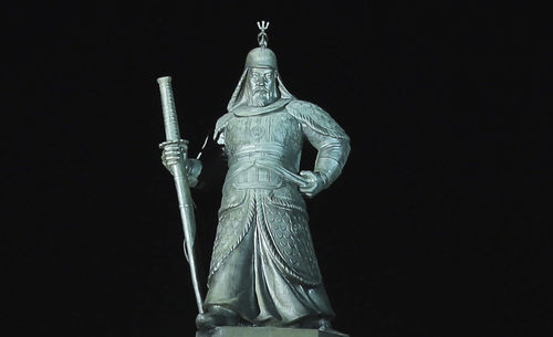 Low angle view of statue against black background