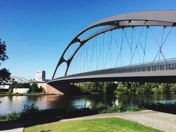 Bridge over river in city against clear sky