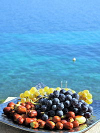 High angle view of grapes in container by swimming pool