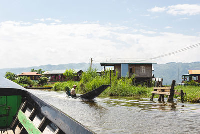 Houses by lake against sky