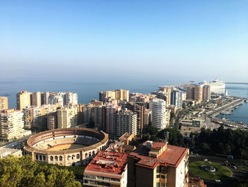 High angle view of port and city buildings against clear sky