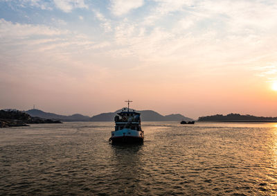 Sunset over river horizon with ship at the centre