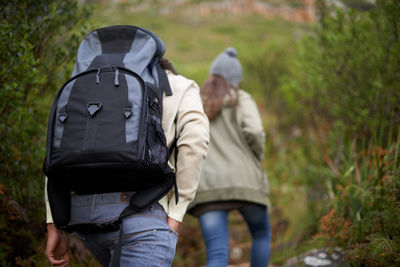 Rear view of couple walking on field