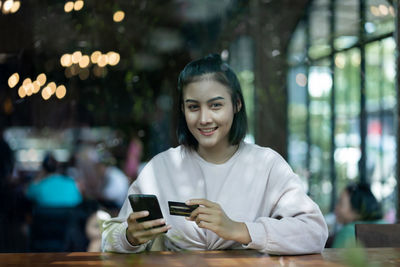 Portrait of smiling young woman using mobile phone