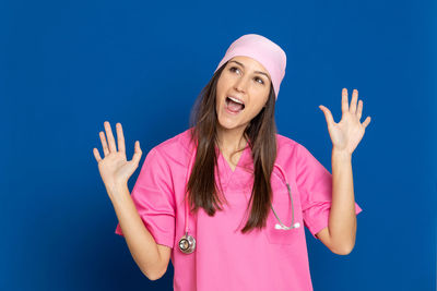 Portrait of a young woman against blue background